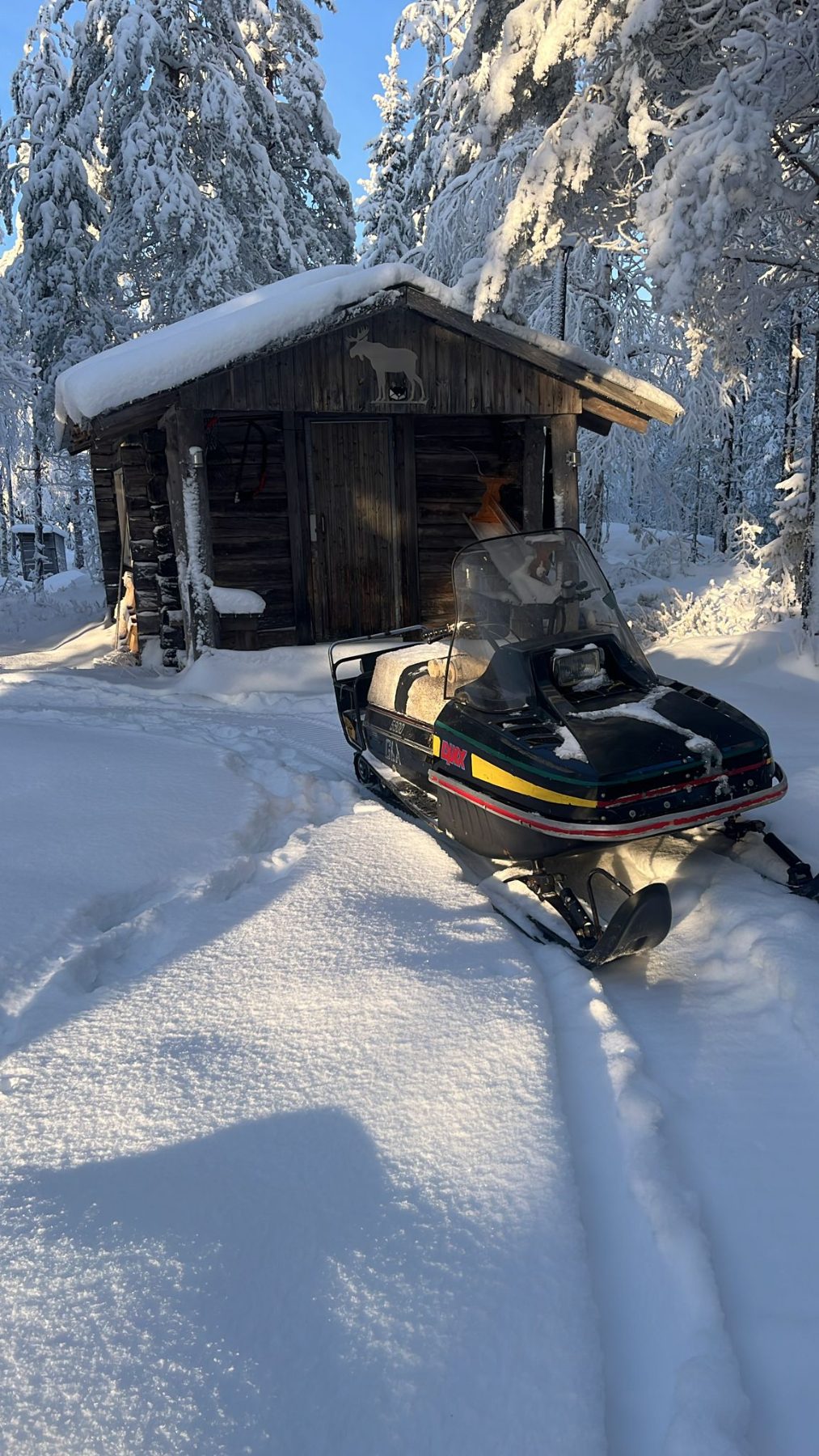 Moottorikelkka kodan pihalla talvella